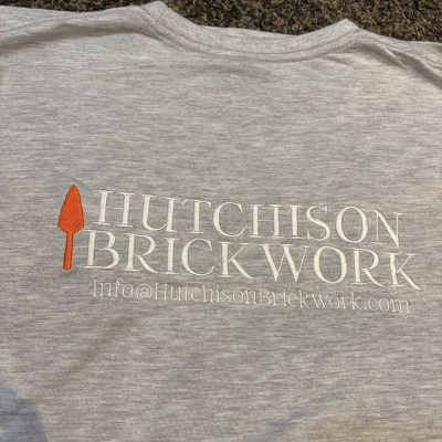 Grey custom workwear T-shirt with large Hutchison Brickwork embroidered back logo in white and orange by KMVT Workwear
